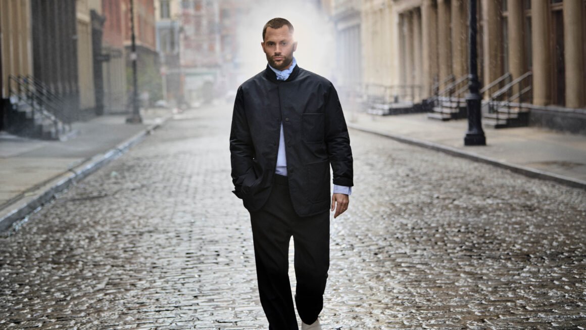 a man in center walking on city streets 