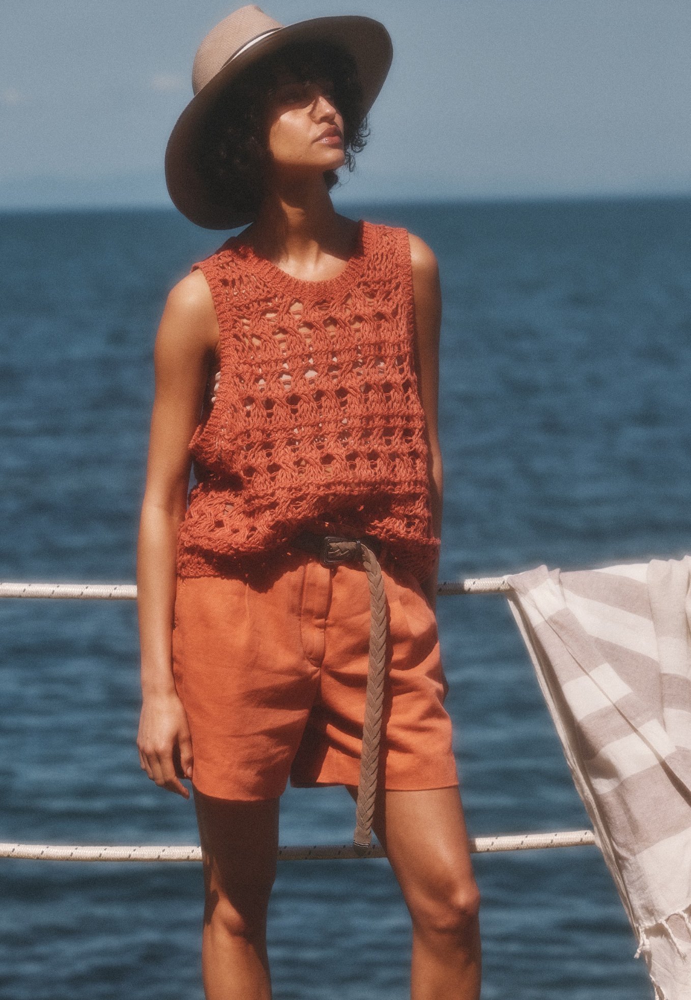 A women posing against sea wearing knitted top