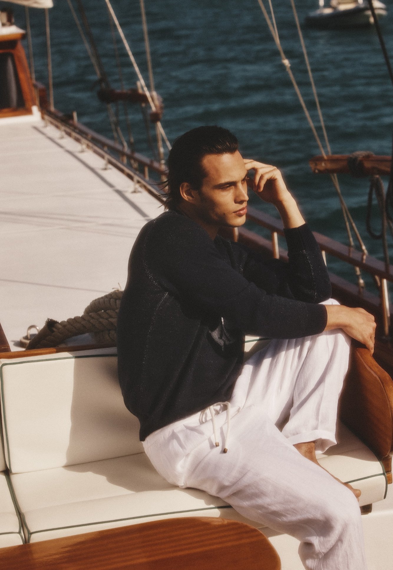 A man sitting in yacht wearing old money outfit