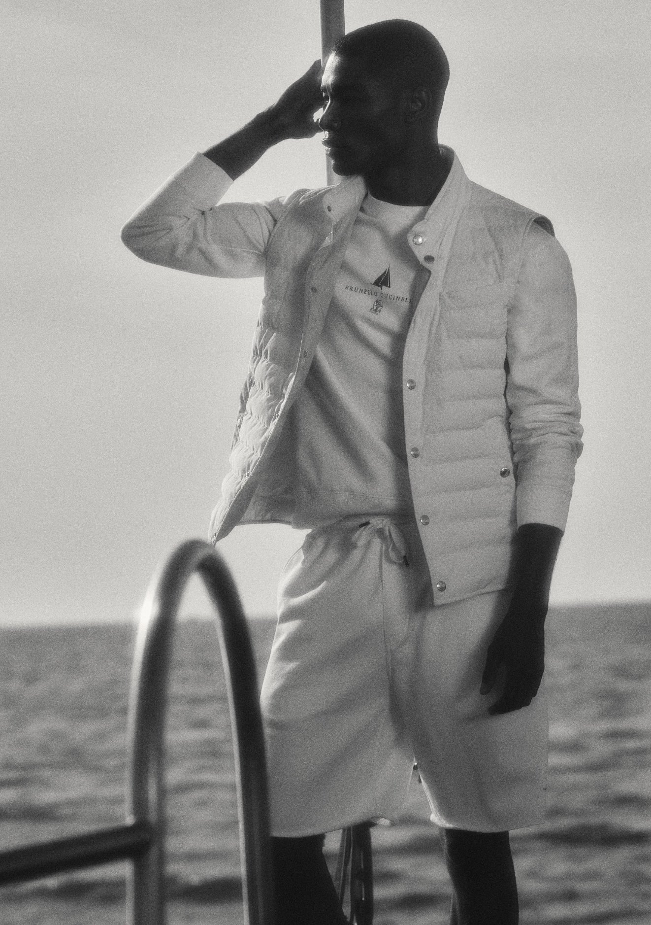 A man standing near sea wearing white casual outfit